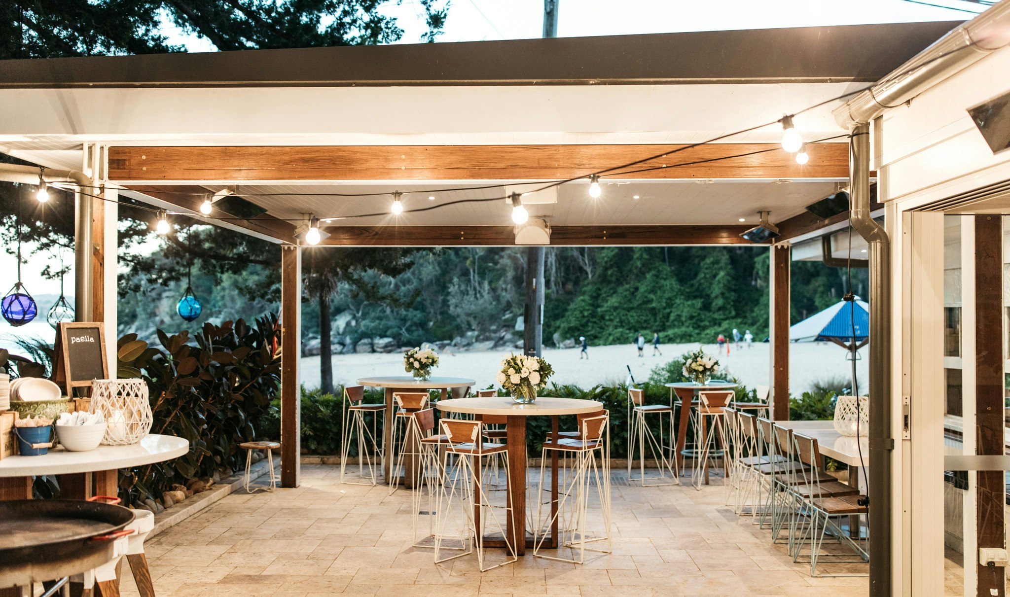 Outdoor wedding reception area with views of the sand and water.